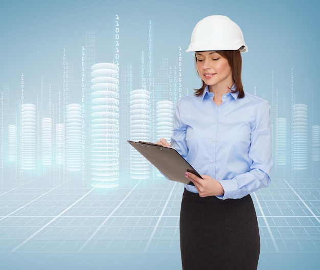 gebouw, ontwikkeling, constructie en architectuurconcept - glimlachende zakenvrouw in witte helm met klembord