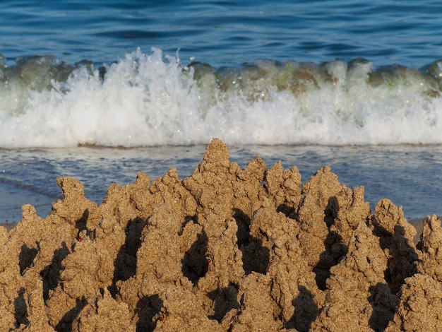 Gebouwd huiszandkasteel met torens aan de zuidkust van het zandstrand blauwe zee