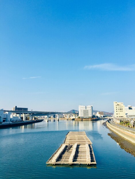 Foto gebouwen bij de rivier tegen een blauwe hemel