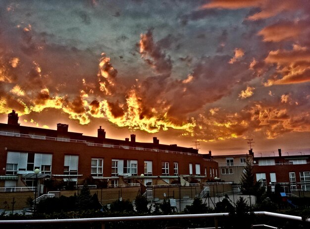 Foto gebouwen tegen een bewolkte hemel bij zonsondergang