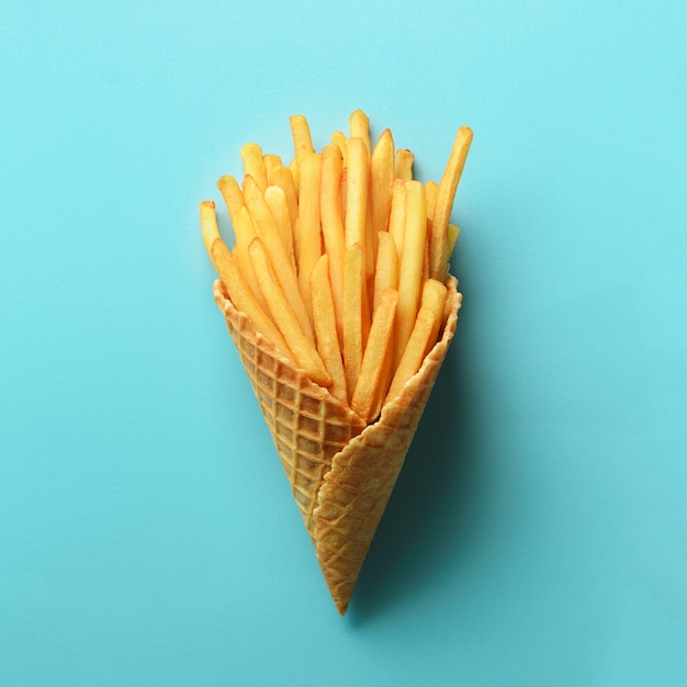 Gebraden aardappels in wafelkegels op blauwe achtergrond. Hete zoute frieten met tomatensaus. Fast food, junk food, dieet concept.