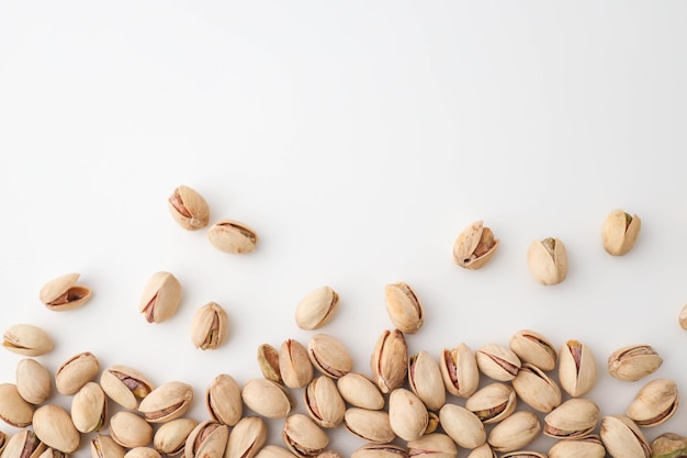 Gebraden en gezouten pistachios in schil op witte achtergrond