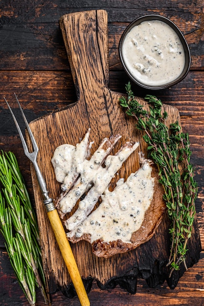 Gebraden filet rundvlees biefstuk met pepersaus op houten bord