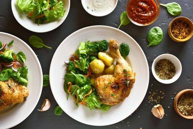 Foto gebraden kippenbeen met aardappel en groene salade