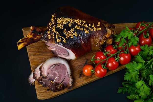 Gebraden varkenspoot en ingrediënten close-up op een leisteen bord Traditionele Europese keuken