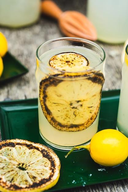 Foto gebrande citroen limonade in glas versierd met verbrande citroensnijden