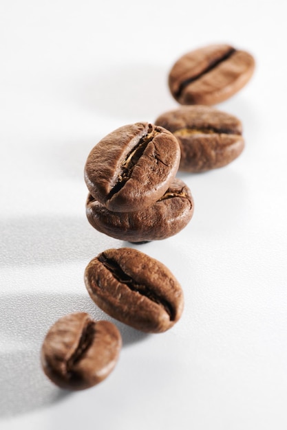 Gebrande koffiebonen geïsoleerd close-up op witte achtergrond uitknippad