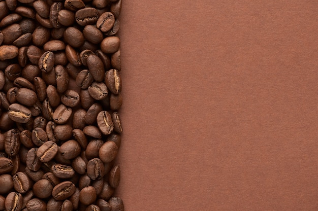 Gebrande koffiebonen op bruine achtergrond met kopie ruimte. Close-up bovenaanzicht. Hoge kwaliteit foto