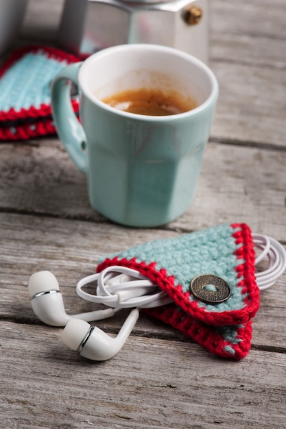 Gebreide earpods-houder op houten tafel