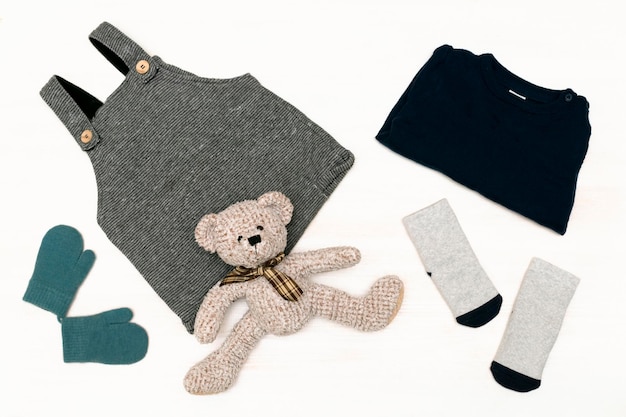 Gebreide romper trui jumper hoed sokken wantenbear speelgoed set van fashion pasgeboren baby kinderkleding en accessoires in pastel kleuren op witte achtergrond plat lag bovenaanzicht