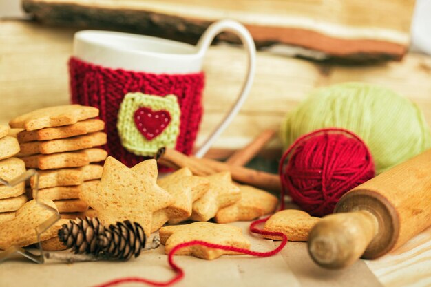 Gebreide wollen kopjes op een houten tafel en prachtige heerlijke kerstpeperkoek