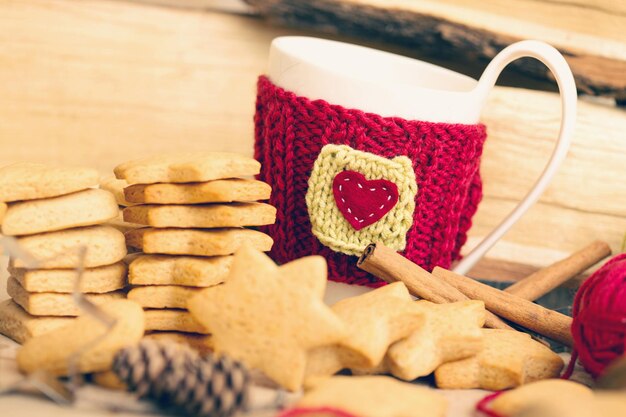 Gebreide wollen kopjes op een houten tafel en prachtige heerlijke kerstpeperkoek