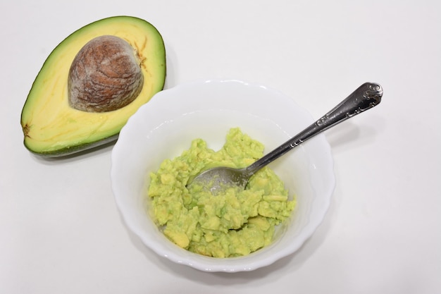 gebroken avocado in een kom met anderhalve theelepel avocado