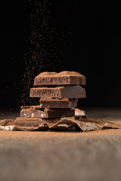 Gebroken chocolade op bakkerijpapier op houten tafel