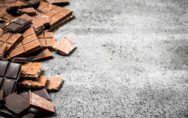 Gebroken chocoladerepen. op een rustieke tafel.