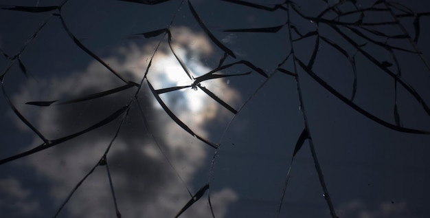 Gebroken glas over hemel en zon achter de wolkenachtergrond