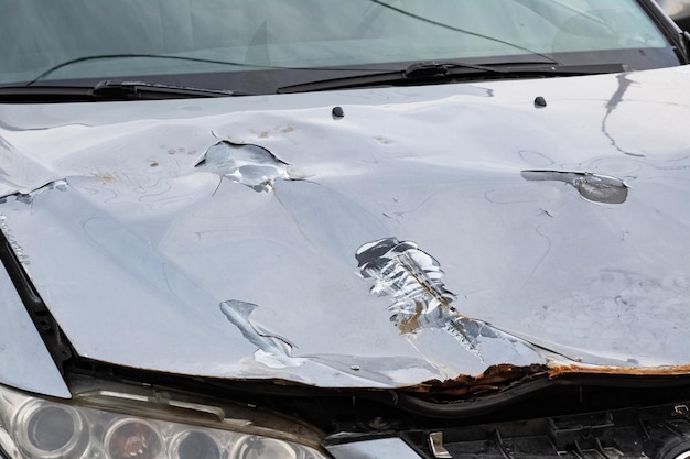 Foto gebroken kap van een grijze auto close-up