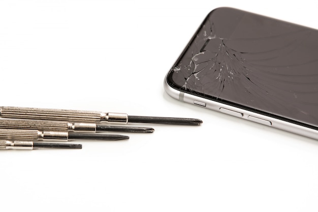 Gebroken smartphone en kleine schroevendraaiers voor reparatie