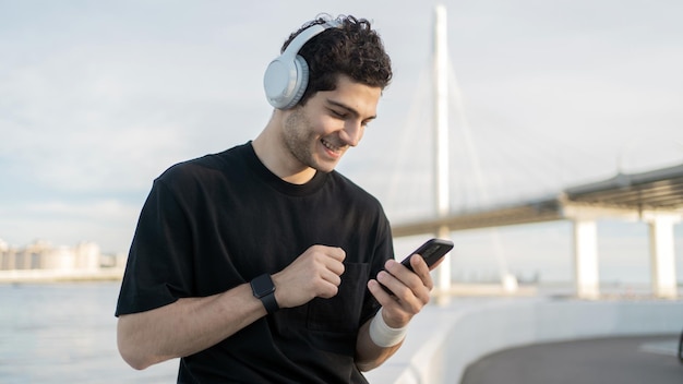 Gebruikt een fitness-app op de telefoon luistert naar muziek een mannelijke atleet loper doet een training