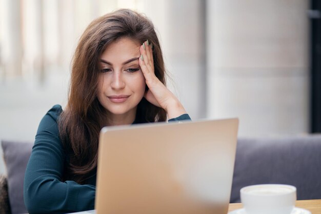 Gebruikt een laptop en schrijft een bericht naar de klant een vrouw in een formele jurk is aan het werk