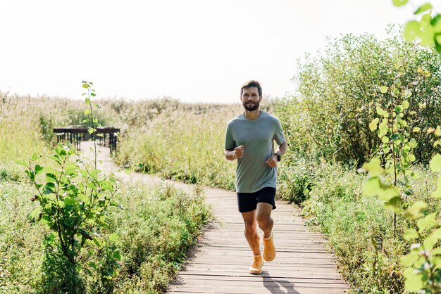 Foto gebruikt een smartwatch op zijn hand en een fitness-app mannelijke atleet positieve groei sterke oefening