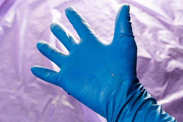 Foto gebruikte blauwe veiligheidshandschoen met perforatiegaatje aan de binnenkant van de handpalm