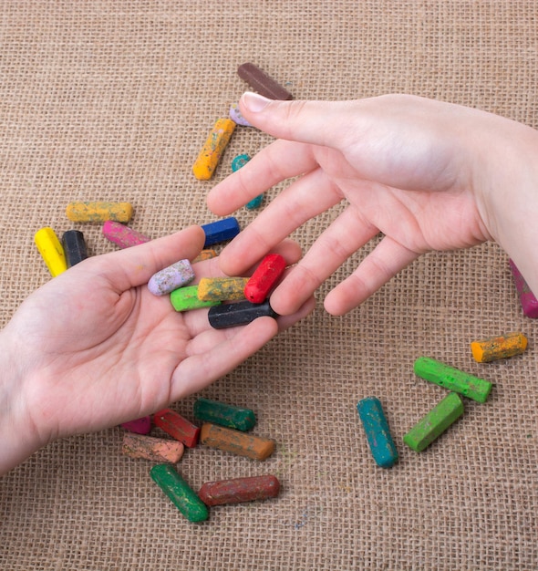 Gebruikte kleurkrijtjes en de handen van een tiener