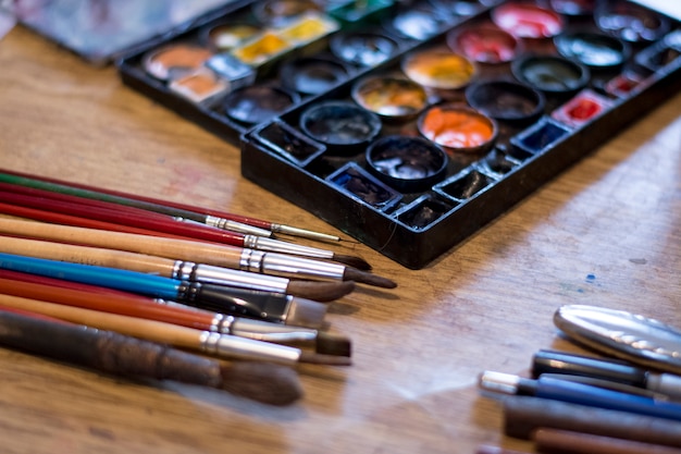 Gebruikte verfborstels op de tafel in atelier van de kunstenaar