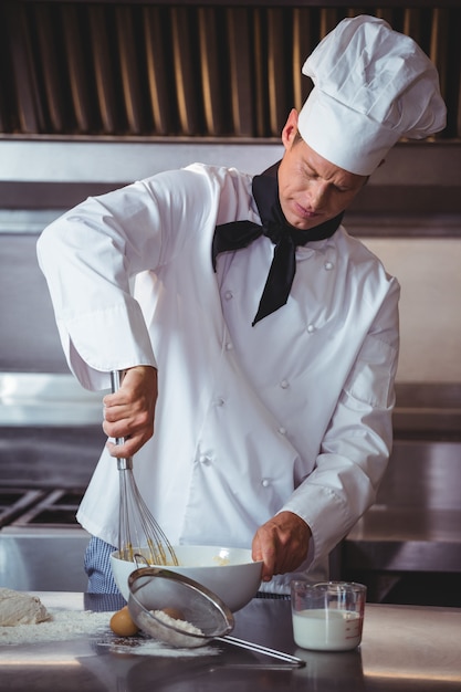 Geconcentreerde chef-kok die een cake voorbereidt