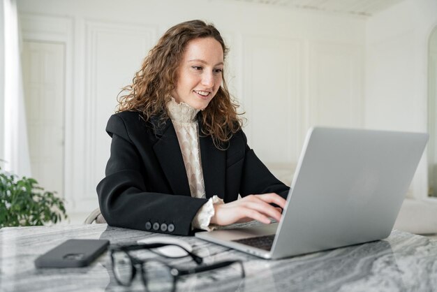 Geconcentreerde jonge professional die op een laptop werkt in een serene en elegante werkruimte