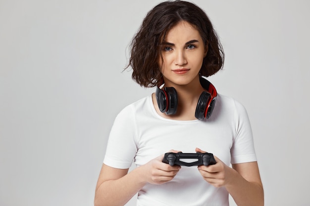 Geconcentreerde jonge vrouw die videogames speelt op de console
