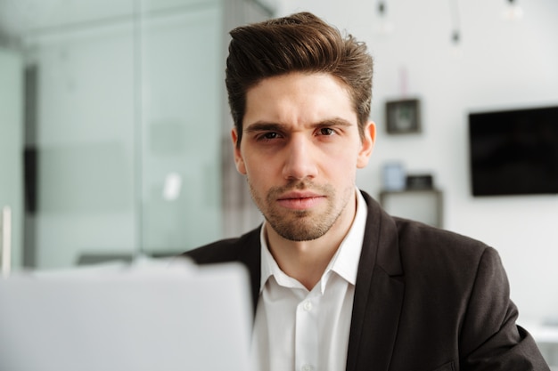 Geconcentreerde jonge zakenman die binnen werkt