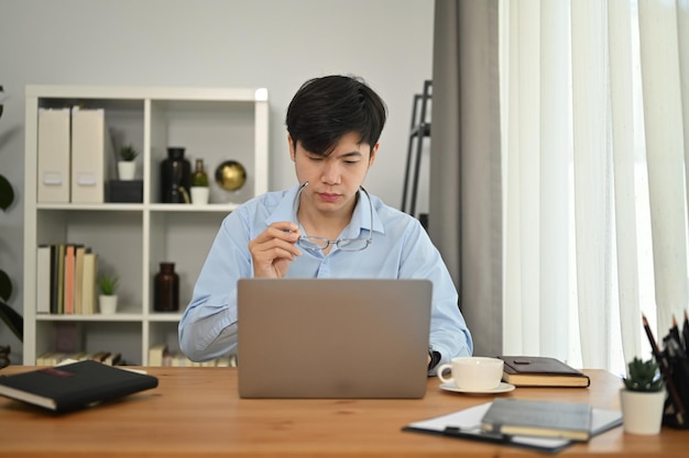 Geconcentreerde man-manager die naar laptop kijkt, online webinar-training bekijkt of een virtuele videoconferentie houdt op kantoor