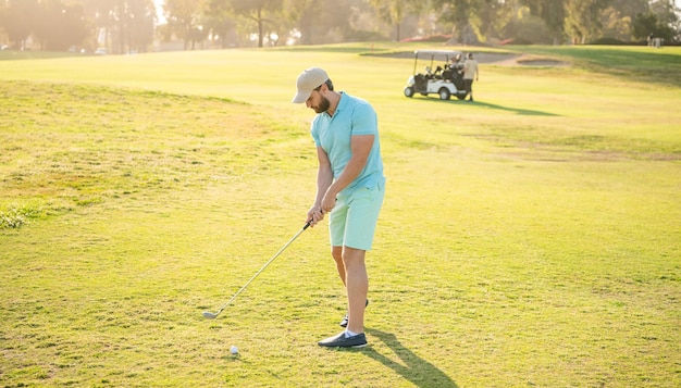 Geconcentreerde mannelijke golfspeler op professionele cursus met groene grasgolfschommeling