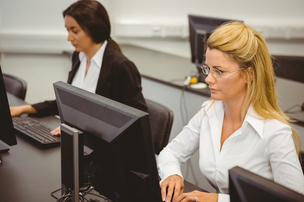 Geconcentreerde onderneemsters die in computerzaal werken