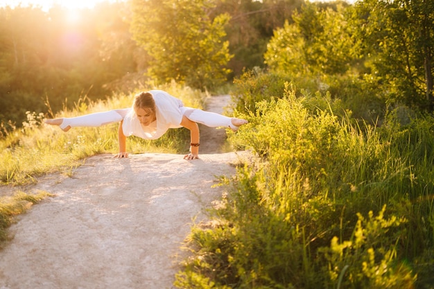 Geconcentreerde sportieve vrouw die Firefly pose uitvoert Meisje doet yoga-oefeningen leunend op handen