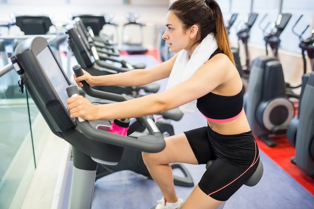 Geconcentreerde vrouw die de hometrainer met behulp van