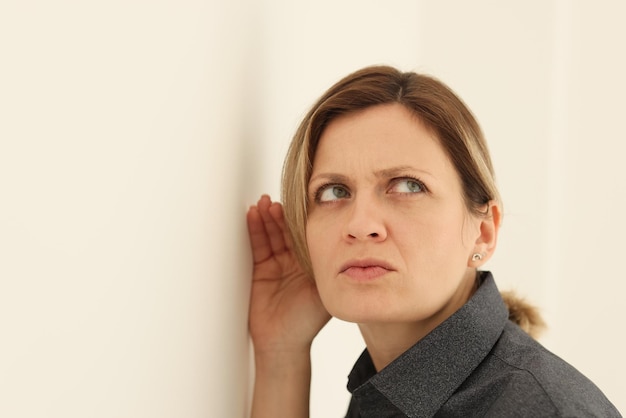 Geconcentreerde vrouw luistert naar de discussie van vrienden in de keuken, attente vrouwelijke persoon legt oor