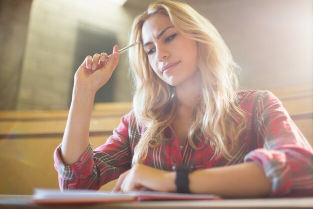 Foto geconcentreerde vrouwelijke student tijdens klasse in collegezaal