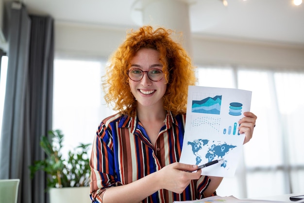 Foto geconcentreerde zakenvrouw die grafieken en grafieken presenteert op videogesprek online jonge zakenvrouw met conferentieoproep met klant op laptop jonge vrouw die uitlegt hoe zaken werken