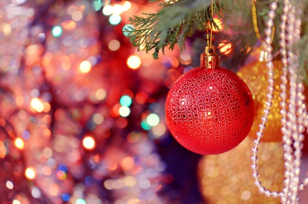 Gedecoreerde kerstboom close-up en rode kerstbal