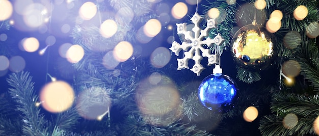 Gedecoreerde kerstboom hangend aan dennentakken en ornamenten