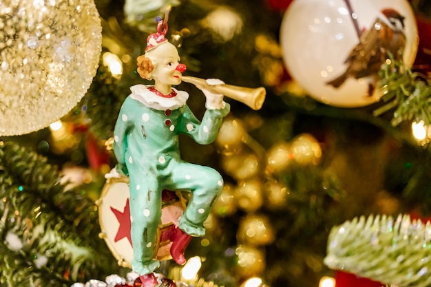 Gedecoreerde kerstboom Kerstavond kerstversiering nieuwjaar Kerstboom speelgoed in de vorm van een clown Selectieve focus Onscherpe achtergrond