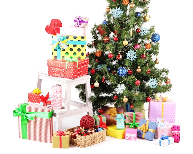 Gedecoreerde kerstboom met geschenken op wit wordt geïsoleerd