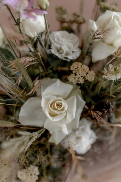 Gedecoreerde tafel met verse bloemen en gedroogde bloemen tegen een papieren beige achtergrond