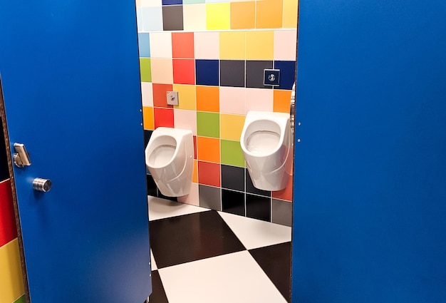 Gedeelde familie heldere toilet met twee pisuars in winkelcentrum winkelcentrum unisex toilet voor man vader jongen kind kind gebruik samen recreatie kamer toilet voor volwassenen kleine zoon grote ouders kinderen cabine