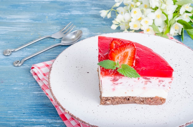 Gedeelte stuk kwark-cheesecake met verse aardbeien en aardbeiengelei