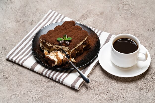 gedeelte van Classic tiramisu dessert en kopje verse espresso koffie op concrete achtergrond