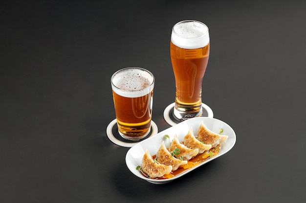 Gedeelte van Japanse gyoza dumplings met bier