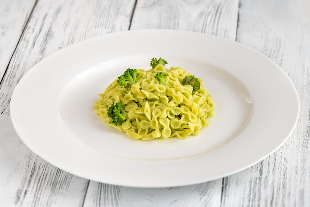 Gedeelte van pasta met broccoli op witte plaat